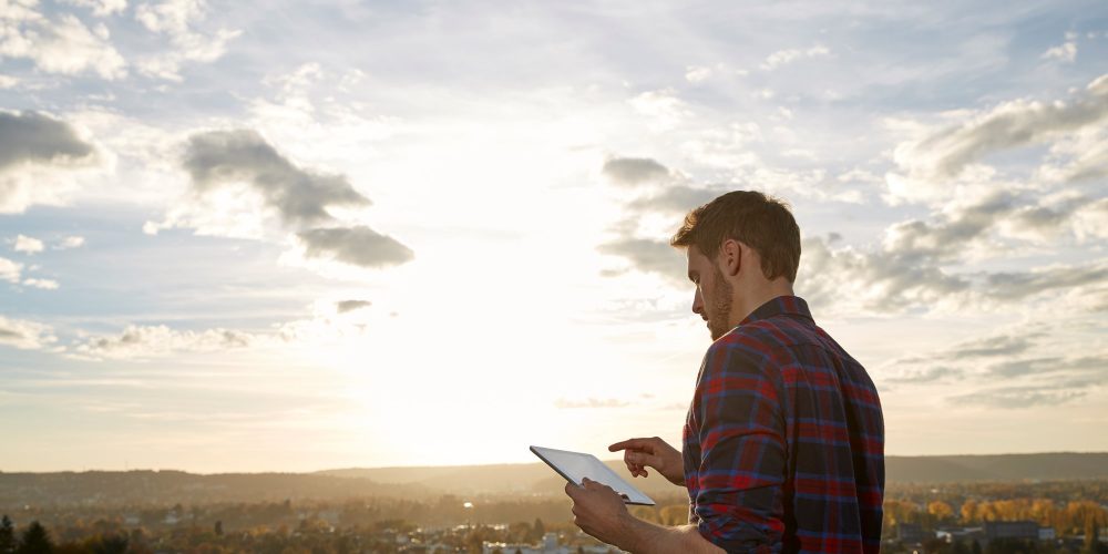 Homme utilisant une tablette à l'extérieur