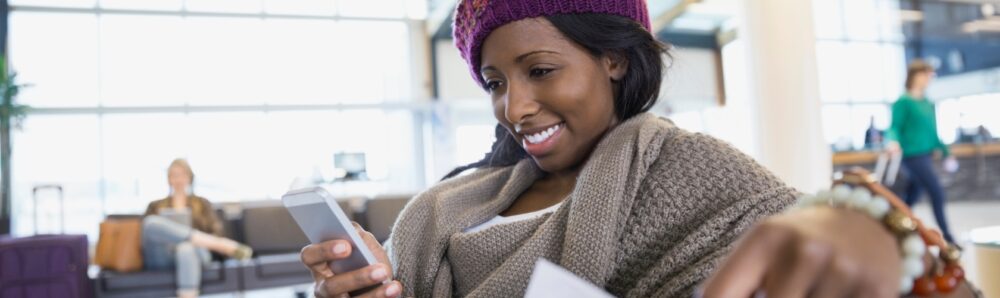 Femme utilisant un smartphone à l’aéroport